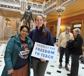Nishelli Ahmed, VP for Social Justice, and Nicole Davidow, member of the Social Justice Committee, who are shown holding a sign